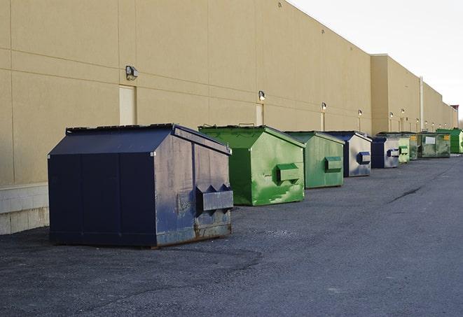 a construction worker empties a wheelbarrow of waste into the dumpster in Browns Summit, NC